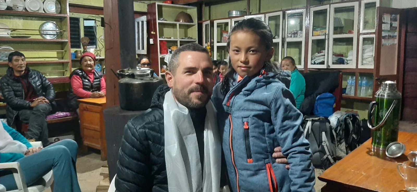 Un parrain, écharpe blanche autour du cou, aux côtés d'une jeune fille dans une salle commune