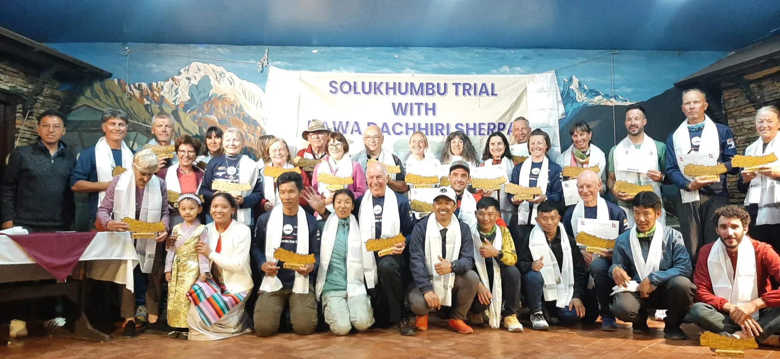 Coureurs et marcheurs du Solukhumbu Trail réunis sous la banderole de la course, khata autour du cou